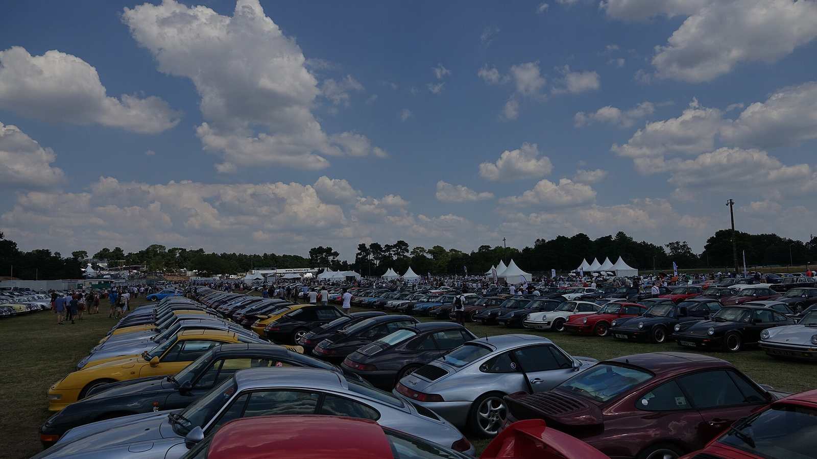 Rows of Porsches in a club parking area at Le Mans Classic in 2018