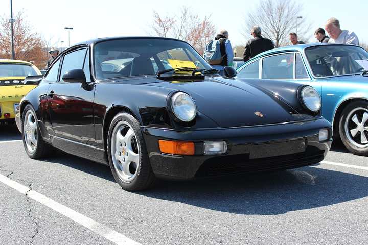 A black Porsche 911 RS America among other air-cooled cars at a Porsche Club of America event
