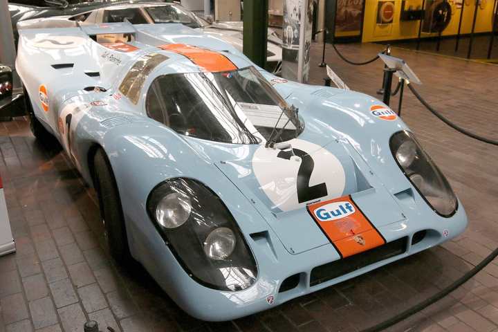 A Porsche 917 K in pale blue and orange Gulf colours on display in a museum