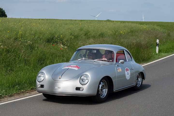 A silver Porsche 356 A coupé on a country road during a classic car rally