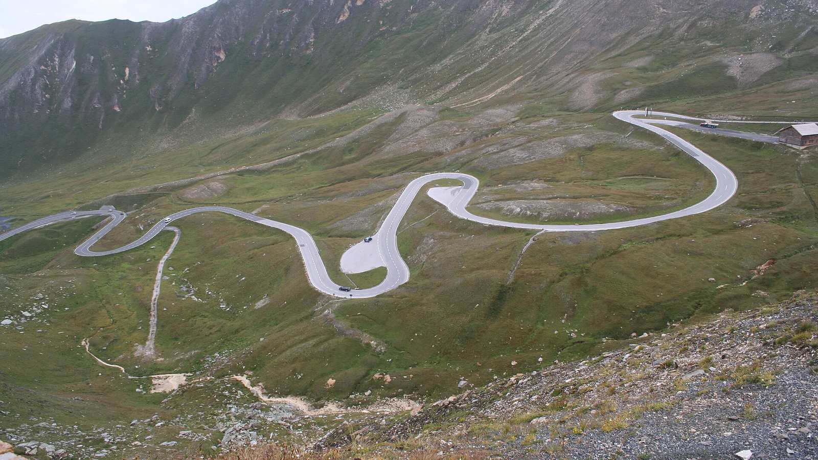 Hairpin bends of the Grossglockner High Alpine Road crossing a green mountainside